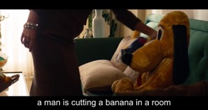 Screenshot from the Disney film 'Saving Mr Banks'. A woman, standing, reaches out her arm to lift a Pluto toy off a sofa.