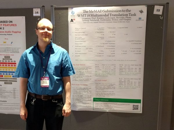 wp4-wmt-poster A conference presenter standing by his research poster representing MeMAD.